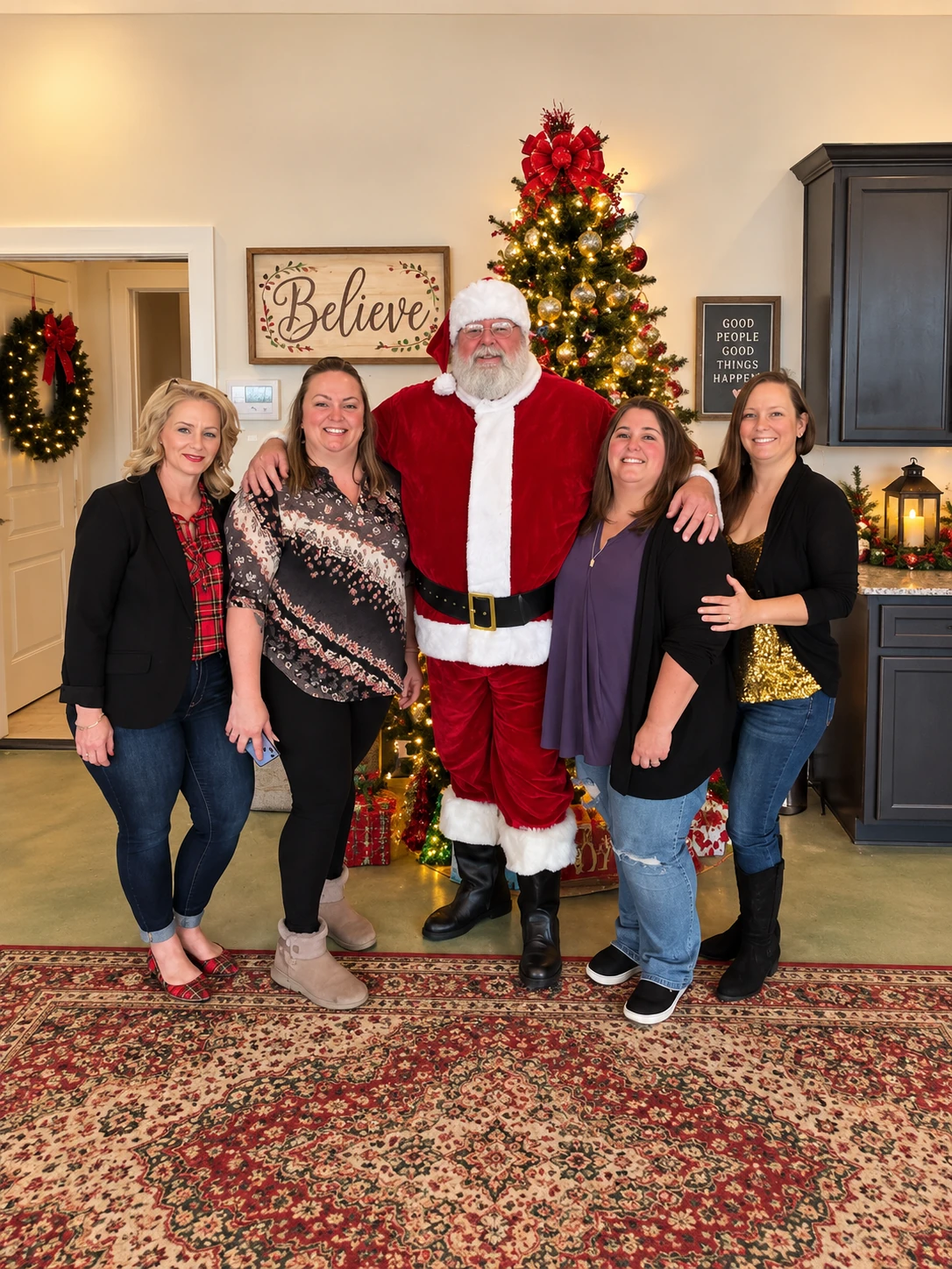 Santa Jeff with four smiling guests beside a decorated Christmas tree